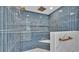 Sleek shower stall featuring blue subway tile, gold fixtures, and a convenient built-in marble bench at 390 Windermere Dr, Lakeland, FL 33809