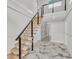 Modern staircase with wood treads, black railings, and marble floors at 390 Windermere Dr, Lakeland, FL 33809