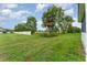 Backyard featuring a green lawn, scattered trees, and a white fence at 6898 Glenbrook Dr, Lakeland, FL 33811