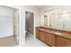 Bathroom with double vanity, granite countertop, and a toilet room with adjacent walk-in closet at 6898 Glenbrook Dr, Lakeland, FL 33811