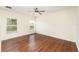 Bright bedroom with wood-look flooring, two windows, and a ceiling fan with light fixture at 6898 Glenbrook Dr, Lakeland, FL 33811