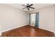 Bedroom with wood-look flooring, a window with curtains, and a ceiling fan with light fixture at 6898 Glenbrook Dr, Lakeland, FL 33811