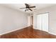 Bedroom with wood-look flooring, a ceiling fan, closet, and an open doorway at 6898 Glenbrook Dr, Lakeland, FL 33811