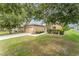 Cozy single-story home boasts a manicured lawn, a two-car garage, and pretty shrubs framing the walkway at 6898 Glenbrook Dr, Lakeland, FL 33811