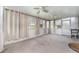 Enclosed sunroom with multiple windows, curtains, and two ceiling fans at 6898 Glenbrook Dr, Lakeland, FL 33811