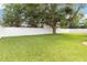 Spacious backyard with lush green grass, mature tree, and a white vinyl fence providing privacy at 8360 Lake Amhurst Trl, Orlando, FL 32829