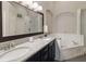 Bathroom featuring double sinks, a large mirror, and a soaking tub at 8360 Lake Amhurst Trl, Orlando, FL 32829