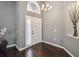 Inviting foyer with dark wood floors, high ceilings, and a modern chandelier at 8360 Lake Amhurst Trl, Orlando, FL 32829