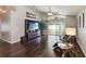Living room with hardwood floors, entertainment center, and access to the backyard at 8360 Lake Amhurst Trl, Orlando, FL 32829