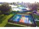 Aerial view of pickleball courts in community, featuring a fenced-in area and view of pool beyond at 8360 Lake Amhurst Trl, Orlando, FL 32829