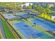 Aerial view of community tennis courts, showing multiple courts with lights and well-maintained landscaping at 8360 Lake Amhurst Trl, Orlando, FL 32829