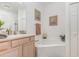 Well-maintained bathroom with a soaking tub, single sink vanity, neutral colors, and natural light at 908 Andalusia Loop, Davenport, FL 33837
