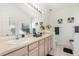 Bright bathroom featuring a double sink vanity, framed mirror, neutral color palette, and decorative accents at 908 Andalusia Loop, Davenport, FL 33837