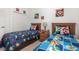 Fun bedroom with themed décor featuring twin beds, a nightstand, and whimsical wall art at 908 Andalusia Loop, Davenport, FL 33837