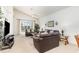 Bright living room featuring vaulted ceilings, comfortable leather sofas, glass tables, and a sliding glass door at 908 Andalusia Loop, Davenport, FL 33837