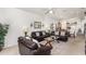 Cozy living room featuring vaulted ceilings, comfortable leather sofas, glass tables, and an open view to the kitchen at 908 Andalusia Loop, Davenport, FL 33837