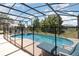 Inviting screened-in pool area with comfortable seating, a hot tub, and a secure safety fence at 908 Andalusia Loop, Davenport, FL 33837