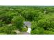 Aerial view of a property surrounded by lush greenery and mature trees with a long driveway at 9530 Sw 189Th Ct, Dunnellon, FL 34432
