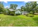 Well-maintained backyard with lush green grass, manicured landscaping, and a screened-in porch at 9530 Sw 189Th Ct, Dunnellon, FL 34432