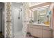 Well-maintained bathroom with a glass shower and vanity, enhanced by floral wallpaper at 9530 Sw 189Th Ct, Dunnellon, FL 34432