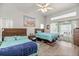 Bright bedroom with two beds, ceiling fan, and sliding door access to outdoor space at 9530 Sw 189Th Ct, Dunnellon, FL 34432