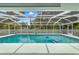Sparkling in-ground pool enclosed in a screened lanai, perfect for relaxation and recreation at 9530 Sw 189Th Ct, Dunnellon, FL 34432