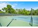 Outdoor tennis courts with well-maintained green and blue surfaces, surrounded by lush landscaping at 9530 Sw 189Th Ct, Dunnellon, FL 34432