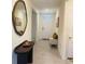 Entryway with tiled floor, a soft white bench, a dark console table and art at 3974 Mekong Ct, St Cloud, FL 34772