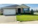 A single-story home with a two car garage, a well maintained lawn, and a tidy landscape design at 3974 Mekong Ct, St Cloud, FL 34772