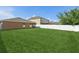 The spacious backyard is surrounded by a white vinyl fence and lush green grass at 109 James Cir, Lake Alfred, FL 33850