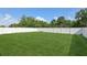 View of a expansive backyard enclosed with a bright white privacy fence and verdant landscaping at 109 James Cir, Lake Alfred, FL 33850