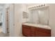 Bright bathroom with double sinks, wood cabinets, and a large mirror with lighting at 109 James Cir, Lake Alfred, FL 33850