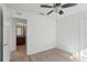 Bedroom featuring wood-look floors and ceiling fan, connected to ensuite bathroom at 109 James Cir, Lake Alfred, FL 33850