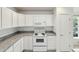 Updated kitchen showcasing white cabinets and countertops at 109 James Cir, Lake Alfred, FL 33850