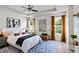 Inviting bedroom with a tray ceiling, ceiling fan, hardwood floors, and large windows with custom curtains at 109 James Cir, Lake Alfred, FL 33850