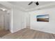 Bright main bedroom featuring wood-look floors, a tray ceiling, and a ceiling fan at 109 James Cir, Lake Alfred, FL 33850
