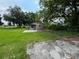Expansive backyard with a concrete slab, partially obscured by overgrown grass and mature trees at 408 S Orange Ave, Fort Meade, FL 33841