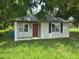 Charming single-story home with a front door flanked by large windows and green lawn at 408 S Orange Ave, Fort Meade, FL 33841