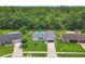 Aerial view of home featuring an in-ground pool, well manicured lawn, and mature trees in the back at 34 Aaron Cir, Ormond Beach, FL 32174