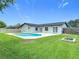 Spacious backyard featuring a sparkling pool, patio, and lush green lawn, ideal for outdoor living and entertaining at 34 Aaron Cir, Ormond Beach, FL 32174