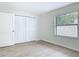 Bright bedroom features wood-look tile flooring, a window and a closet with bifold doors at 34 Aaron Cir, Ormond Beach, FL 32174