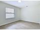 A bright bedroom features wood-look tile floors and a window overlooking the yard at 34 Aaron Cir, Ormond Beach, FL 32174