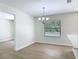 Dining area boasts wood-look tile, modern chandelier, and view of the pool at 34 Aaron Cir, Ormond Beach, FL 32174