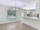 Bright dining area with wood-look tile floors, modern chandelier and view to the pool at 34 Aaron Cir, Ormond Beach, FL 32174