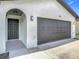 Charming home exterior with brick accents, dark gray garage door and inviting front porch at 34 Aaron Cir, Ormond Beach, FL 32174
