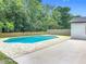Backyard view of a private pool, surrounding brick pavers and mature trees at 34 Aaron Cir, Ormond Beach, FL 32174
