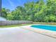 Backyard view of a private pool, fenced yard, and mature trees at 34 Aaron Cir, Ormond Beach, FL 32174