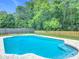 Backyard view of a private pool, lush landscaping, and well-maintained yard at 34 Aaron Cir, Ormond Beach, FL 32174
