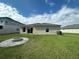 Backyard with fire pit, grass yard, and view of the home's exterior at 1509 Venice Ln, Davenport, FL 33896