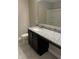 Bathroom vanity features speckled granite counters, dark cabinets and a large mirror above a white sink basin at 1509 Venice Ln, Davenport, FL 33896